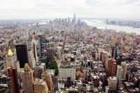 Vista aérea de Manhattan, em Nova Iorque, com numerosos edifícios e o One World Trade Center ao fundo.